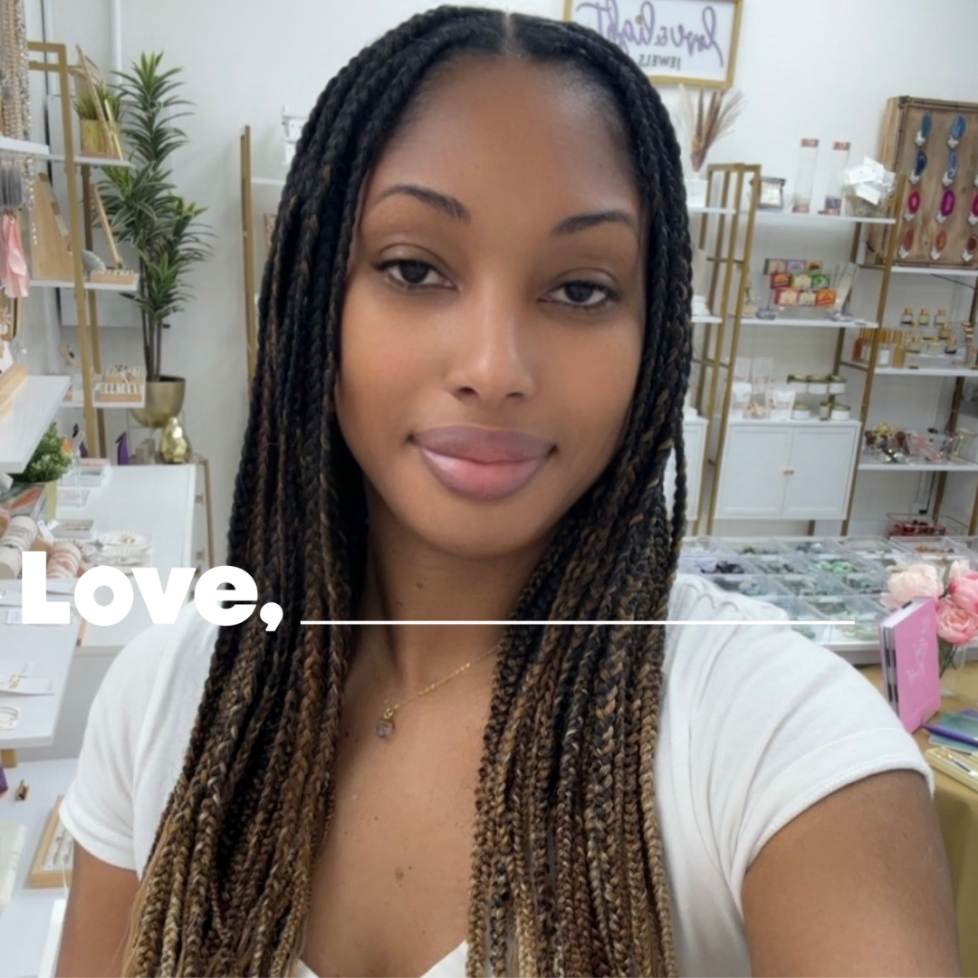 A woman stands in front of a flowered wall